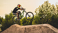 Mountainbiker auf trockenem Trail über den Baumwipfeln.