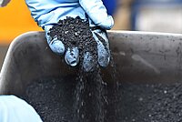 Schwalbe Kreislaufreifen Recycling Fahrradreifen. Gummigranulat in einer Wanne.