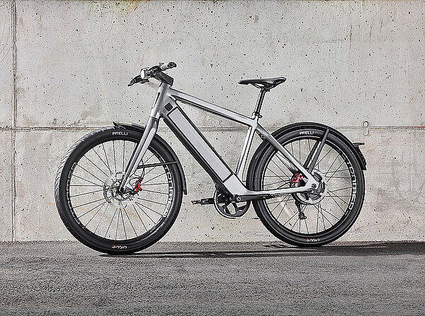 Ein silber graues E-Bike des schweizer Herstellers Stromer steht vor einer Betonwand.