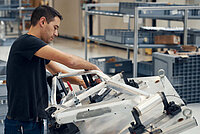 Mann bei der Fertigung eines E-Bikes von Riese & Müller