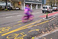 Ein Veloweg in Zürich auf einer autobefahrenen Strasse.