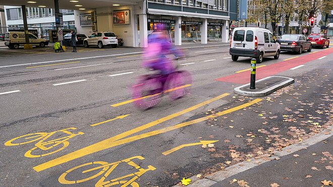 Ein Veloweg in Zürich auf einer autobefahrenen Strasse.