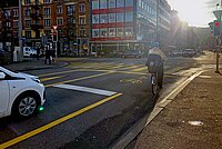 Velofahrerin steht im Velosack genannten Aufstellbereich für Velos.