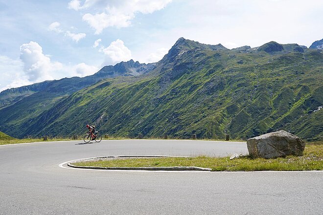 Österreichs Westen ist gebirgig und mit guten, kleinen Strassen erschlossen. Sie laden zu einer Entdeckungsreise über acht knackige Pässe ein. (Foto: Pete Mijnssen) Ein Mann fährt mit dem Rennrad eine Passstrasse hoch