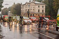 Aktionskunst auf dem Velo. Aktivisten fahren mit Gestellen am Velo, die ein Auto nachahmen.