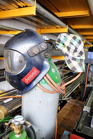 Benno Bikes Portrait. Ein Schweisshelm hängt an einer Gasflasche.