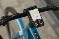 Smartphone mit eBike Flow App von Bosch am Lenker eines E-Bikes.