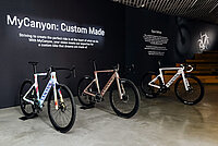 Rennräder stehen vor einer schwarzen Wand.