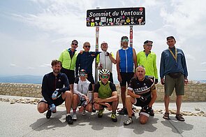 Eine Gruppe posiert vor dem Gipfelschild des Mont Ventoux