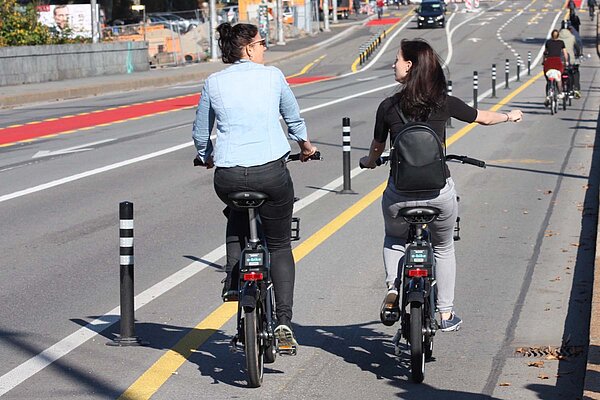 Zwei Frauen fahren mit Velos über die Lorrainebrücke in Bern