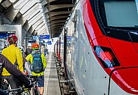 Eine Gruppe Velofahrende bahnen sich ihren Weg in den Zug.