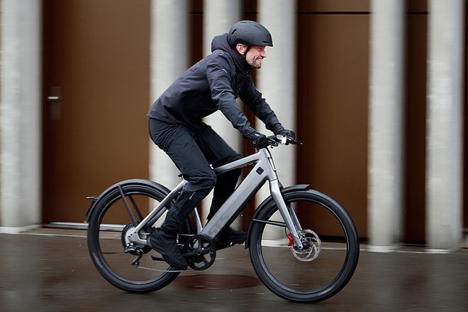 ZIV Studie Speed-Pedelecs. Ein Mann mit Regenbekleidung fährt auf einem E-Bike.