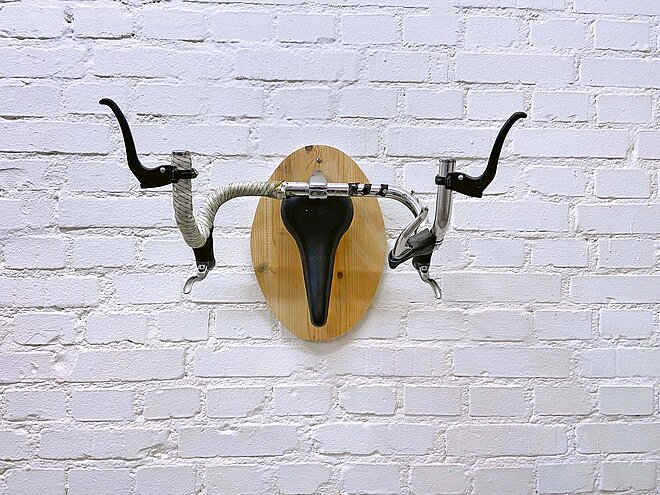 Hirschgeweih veloaufhängung aus Sattel und Lenker an weisser wand aus Backstein