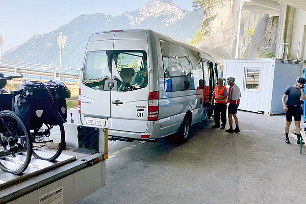 Velofahrverbot Axenstrasse. Shuttlebus mit Anhänger, auf dem Fahrräder stehen.