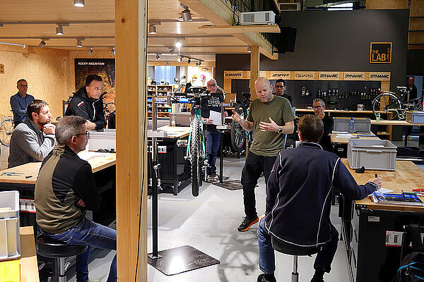 Einstiegskurs für Velowerkstatt-Mitarbeitende. Personen sitzen auf Stühlen in einem Schulungsraum.