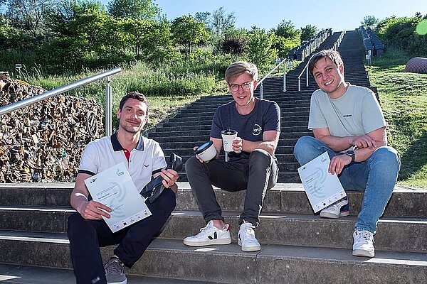 Drei Männer sitzen auf einer Treppe