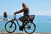 Senior auf Ebike entlang von Seeufer