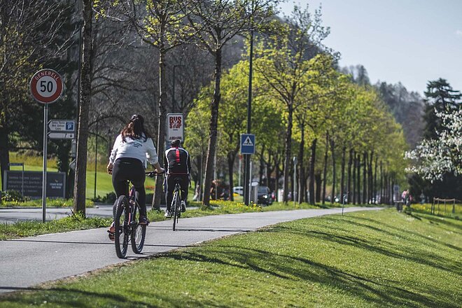 Studie Sport Schweiz Light 2022. Zwei Personen fahren mit Velos auf einem Radweg. 