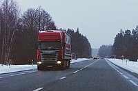 Roter Lastwagen auf verschneiter Strasse 