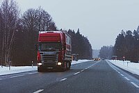 Roter Lastwagen auf verschneiter Strasse 