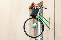 Deloitte Studie Nachhaltigkeit Fahrradindustrie DACH. Ein grünes Fahrrad hängt an einer Mauer.