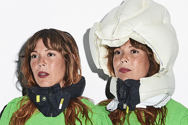 Frau mit grünem Pulli trägt den Air-Bag-Velohelm von Hövding