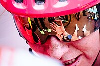 Gesicht einer Radrennfahrerin mit pinkem Helm.