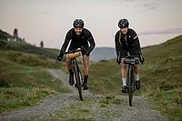 Fazua Firmware Update Ride 50. Eine Frau und ein Mann fahren auf Gravelbikes über einen Schotterweg.