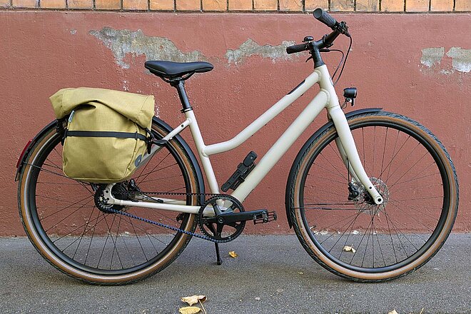 Ein Fahrrad mit Satteltasche steht vor einer Mauer.