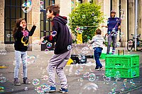 Kinder spielen auf der Strasse mit Seifenblasen