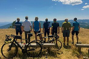Radfahrer stehen auf einer Wiese. 