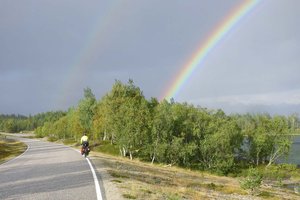 Fahrradtour entlang der Schengen-Grenze. Regenbogen am Himmel.