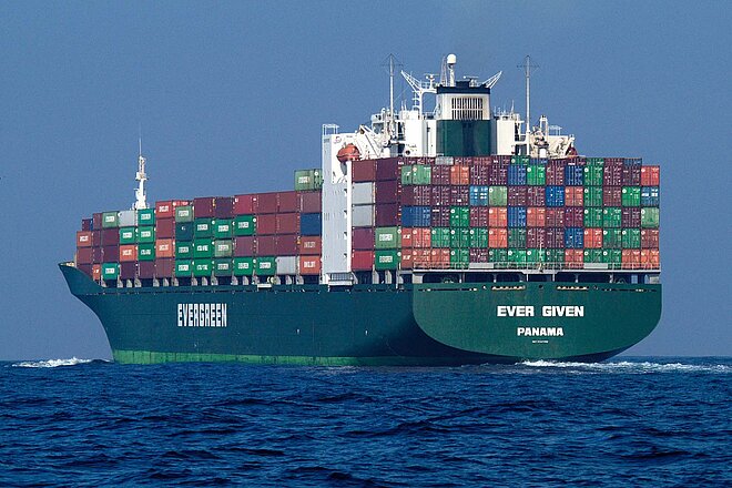 Ein Frachtschiff mit vielen Containern auf dem offenen Meer. 