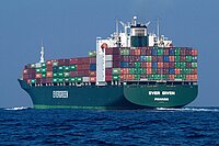 Ein Frachtschiff mit vielen Containern auf dem offenen Meer. 