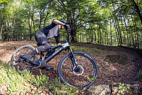BHZ System by SEG BH Bikes. Ein Mountainbiker fährt auf einem Singletrail im Wald.