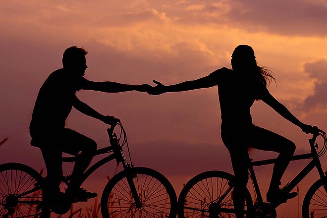 Mit diesen Tipps gelingt die Rückkehr auf den Bikesattel. Zwei verliebte Personen auf dem Velo.
