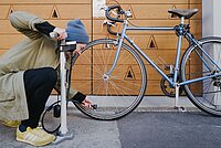 Person pumpt Velo vor Garagentor