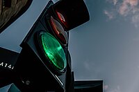 Lichtsignal zeigt grün vor blauem Himmel