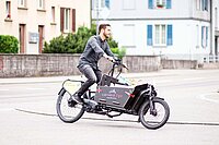 Ein Mann fährt mit einem Latenvelo durch eine Kurve