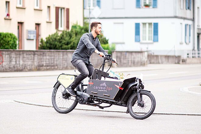 Ein Mann fährt mit einem Latenvelo durch eine Kurve