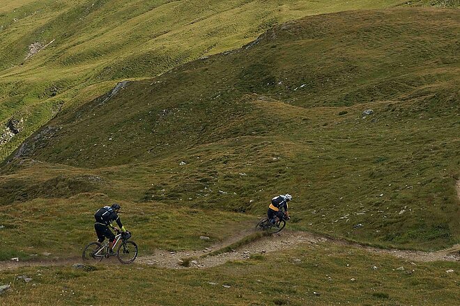 Zwei Mountainbiker in hügeliger Landschaft im Berner Oberland