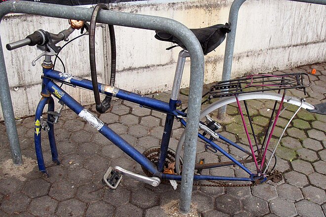 Ein solch tristes Dasein hat kein Velo verdient. Fahrradleiche an einem Bahnhof.