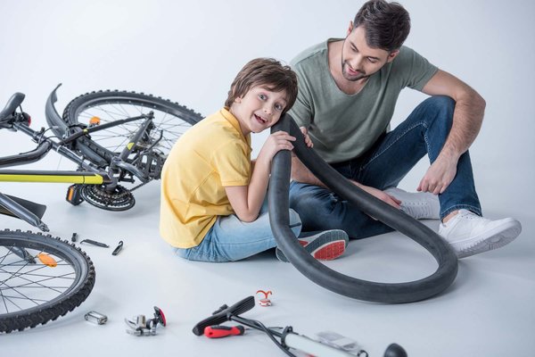 Vater und Sohn reparieren ein Fahrrad.