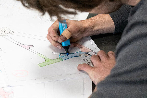 Gamux Bikes Nostra Carbonrahmen Schweiz. Eine Person markiert etwas mit Leuchtstift auf einem Papier.