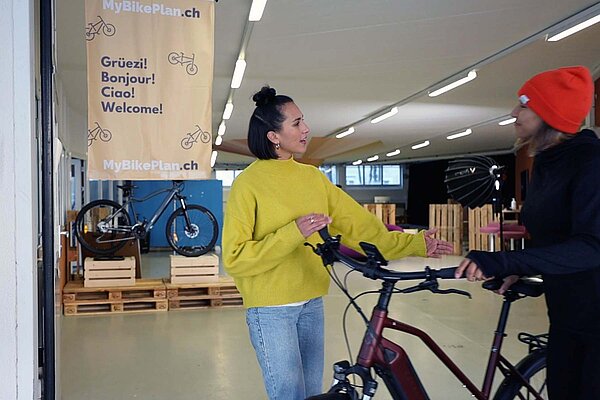 Verkäuferin berät Kundin in Fahrradgeschäft.