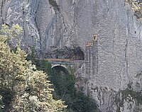 Steinbrücke vor Tunnel in Felswand mit Urnerwappen