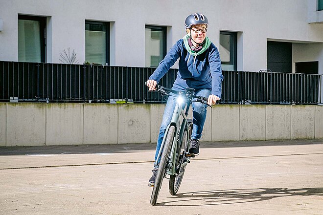 Ein Tagfahrlicht ist bei allen E-Bike-Typen nun Pflicht. Eine Frau fährt mit einem E-Bike