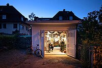 Ein Mann arbeitet in einer Garagenbox an einem Fahrrad.