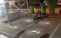 Frisch markierte Parkplätze für Cargobikes neben Einkaufswagen Station in der Nacht