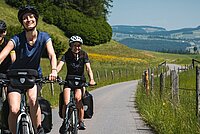 Velo mieten für Velotour. Velofahrer mit Tourenvelo im Grünen.